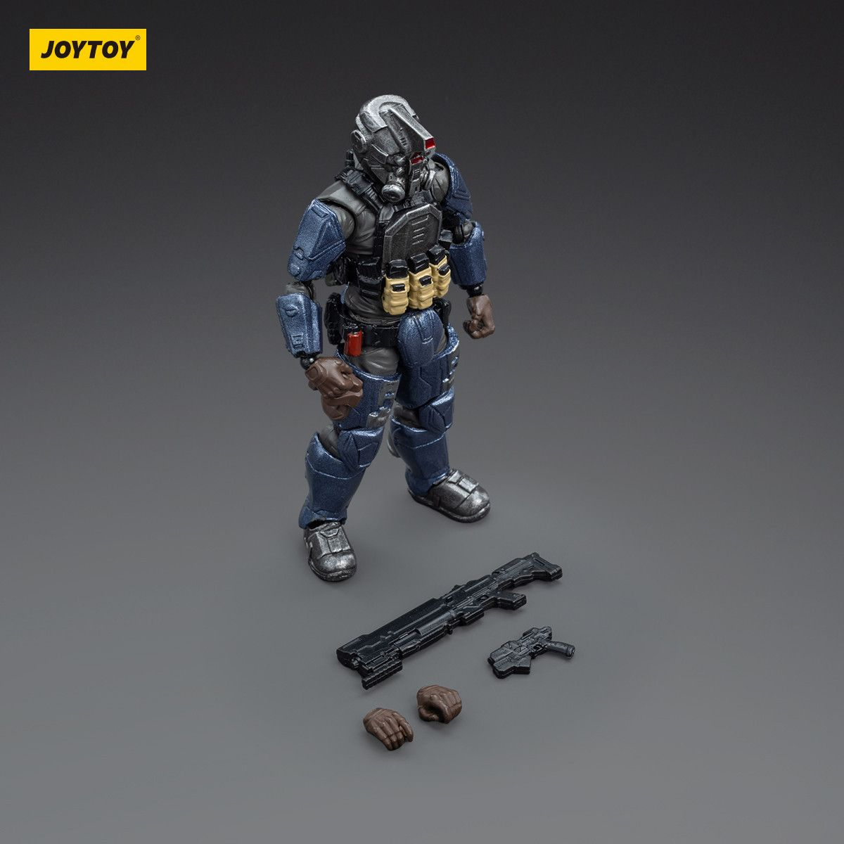 Toy figure in tactical gear with weapons on a gray background, featuring the JOYTOY brand.
