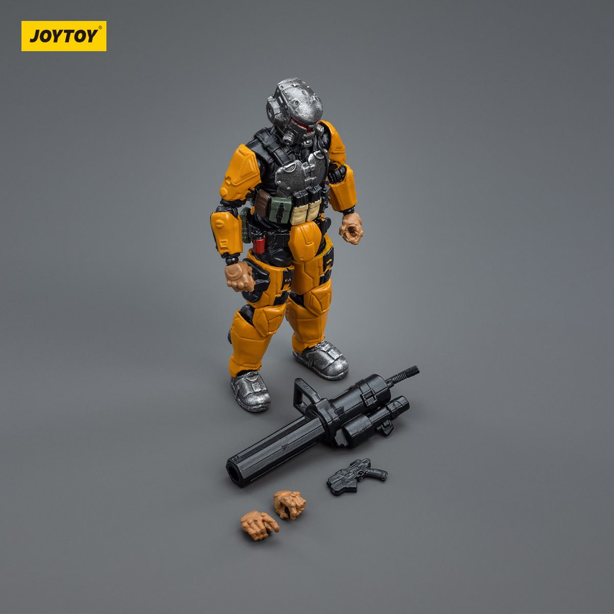 Toy figure in orange and black armor with weapons on a gray background, featuring the JOYTOY brand.