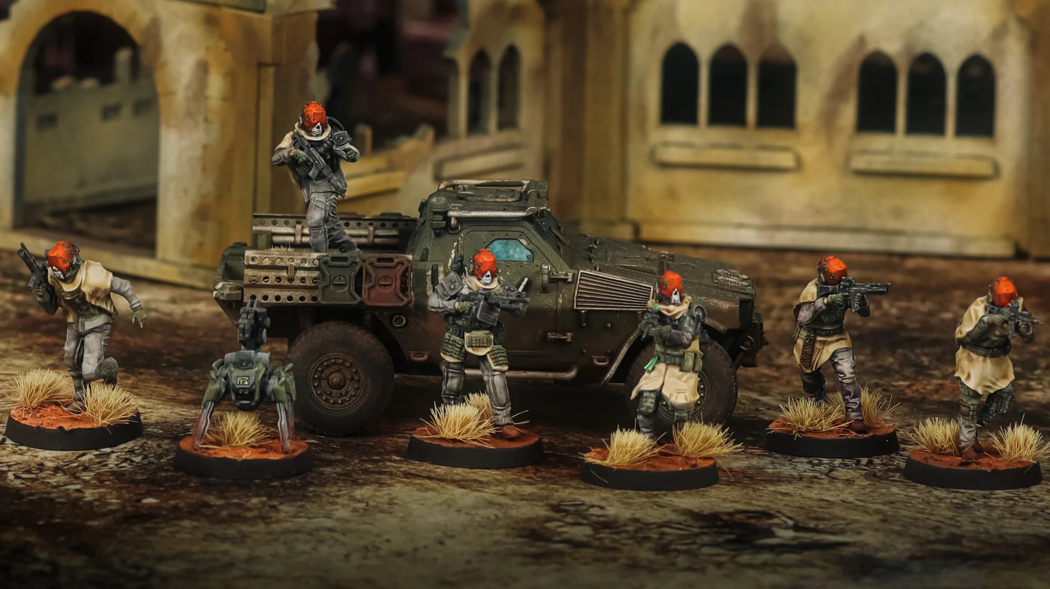 Miniature figures in military gear with an armored vehicle on a textured surface