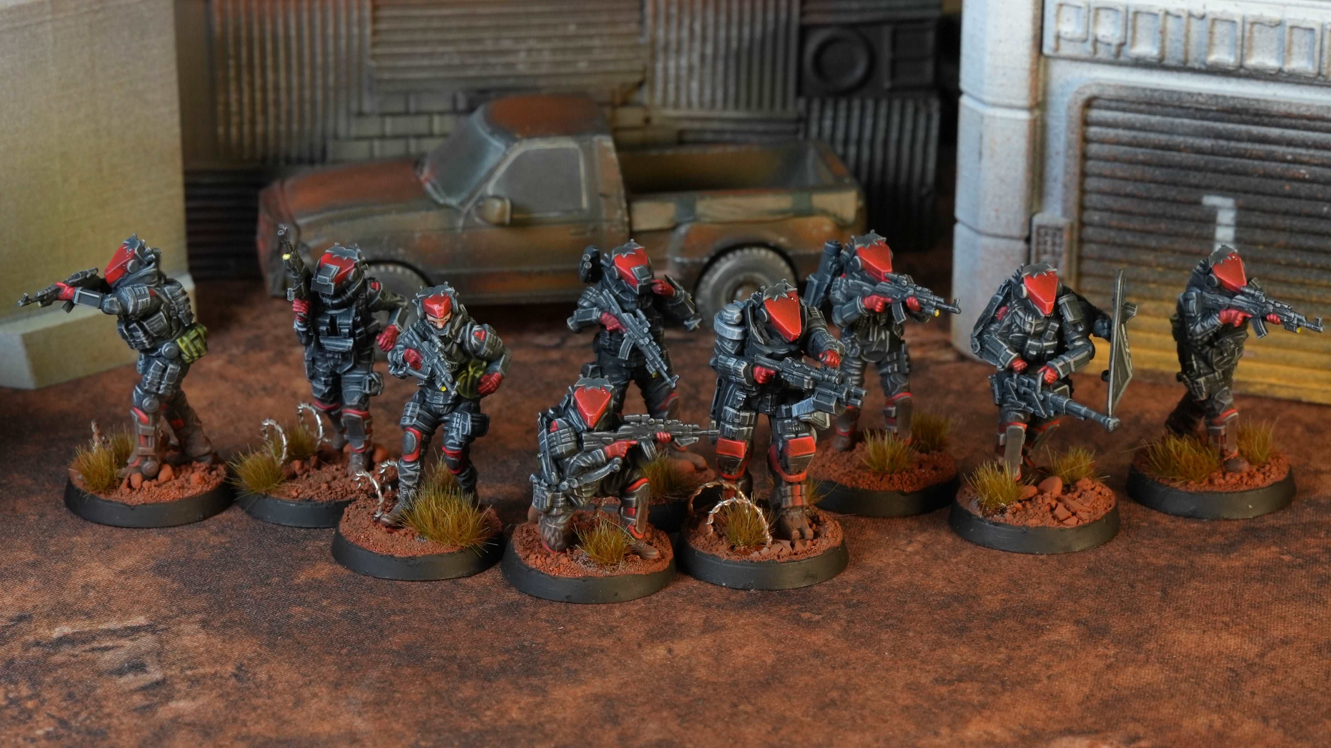 Row of miniature figures in a military or sci-fi setting with a textured surface background.