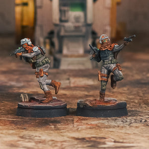 Two miniature figures on a wooden surface with a blurred background