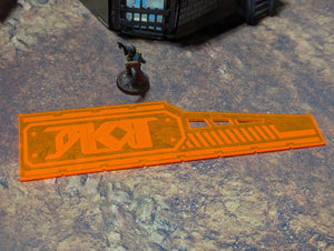 Small figurine on a textured surface with an orange rectangular object labeled 'TAKO' in the foreground.