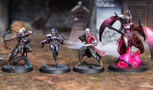 Four miniature figurines on a textured surface with a blurred background