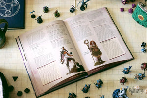 Open book on a gaming mat with character illustrations and game pieces around