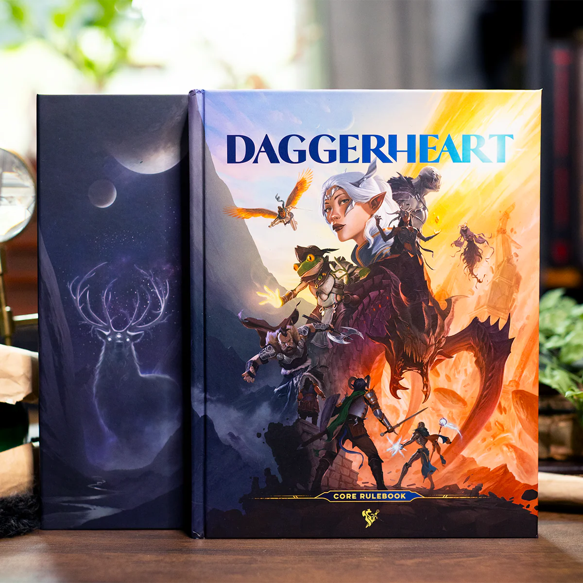 Two books titled 'Daggerheart' and another with a celestial design on a wooden surface.