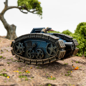Toy tank on a rocky surface with greenery in the background