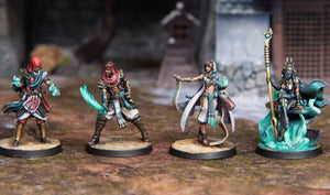 Four miniature figurines on a textured surface with a blurred background